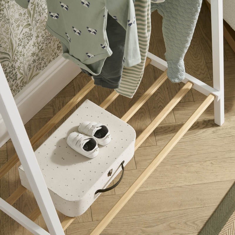  The shoes storage of the clothes rail from the Cuddleco Nola Scandi Cot Bed & Room Sets next to the nursing chair | Nursery Furniture Sets | Room Sets | Nursery Furniture - Clair de Lune UK