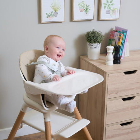 Baby girl smiling in the Beige and white 6in1 High Chair next to the sideboard in the kitchen | High Chairs | Baby Feeding Essentials - Clair de Lune UK