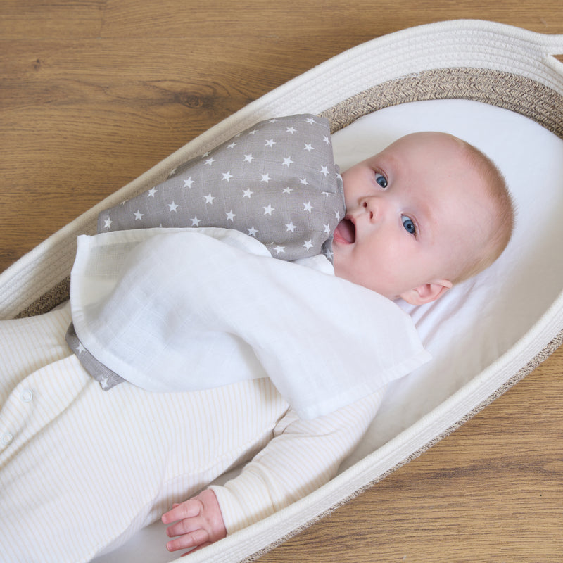 Newborn baby lying in the Moses basket holding a grey muslin square | Feeding Essentials | Feeding & Weaning | Toddler Essentials - Clair de Lune UK