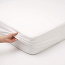 Close up of a hand adjusting the Fitted Mattress Protector to fit Cot/Cot Bed | Soft Baby Sheets | Cot Bed Bedding - Clair de Lune UK