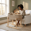 Mum looking in the Champagne Crochet Moses Basket With Stand at her baby in a neutral and calm beige living room | Moses Baby Baskets & Bassinets - Clair de Lune UK