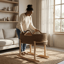 Mum standing looking over baby in the Chocolate Crochet Moses Basket With Stand in a neutral and calm beige nursery | Moses Baby Baskets & Bassinets - Clair de Lune UK