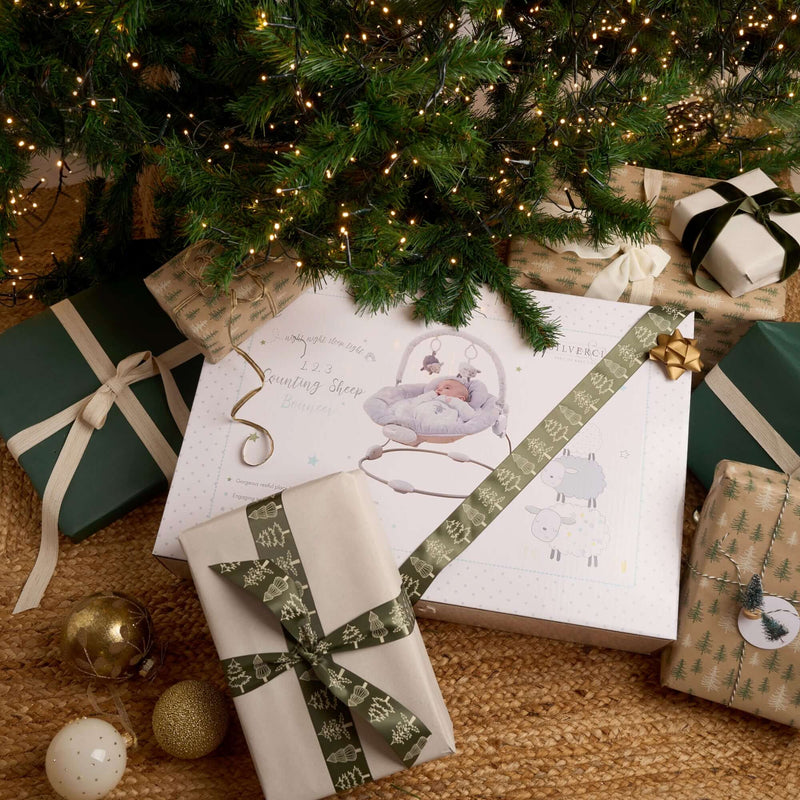 Counting Sheep Baby Bouncer under the Christmas tree wrapped up with beautiful ribbon |  Baby's First Christmas Gift | Baby Toys & Nursery Furniture - Clair de Lune UK