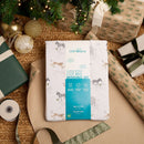 Reversible Jungle Dream Cot Bed Duvet Cover and Pillowcase Set in a gift bag  being wrapped up for Christmas by the tree | Baby and Toddler Bedding | Nursery Linen | Baby Gift Ideas 2025 - Clair de Lune UK