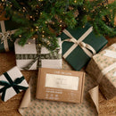 Cream Organic Star Breathable Mesh Baby Wrap Blanket in brown box packaging being unwrapped under the Christmas tree | Cosy Baby Blankets and Swaddles | Newborn Summer Essentials | Baby Christmas Gifts - Clair de Lune UK