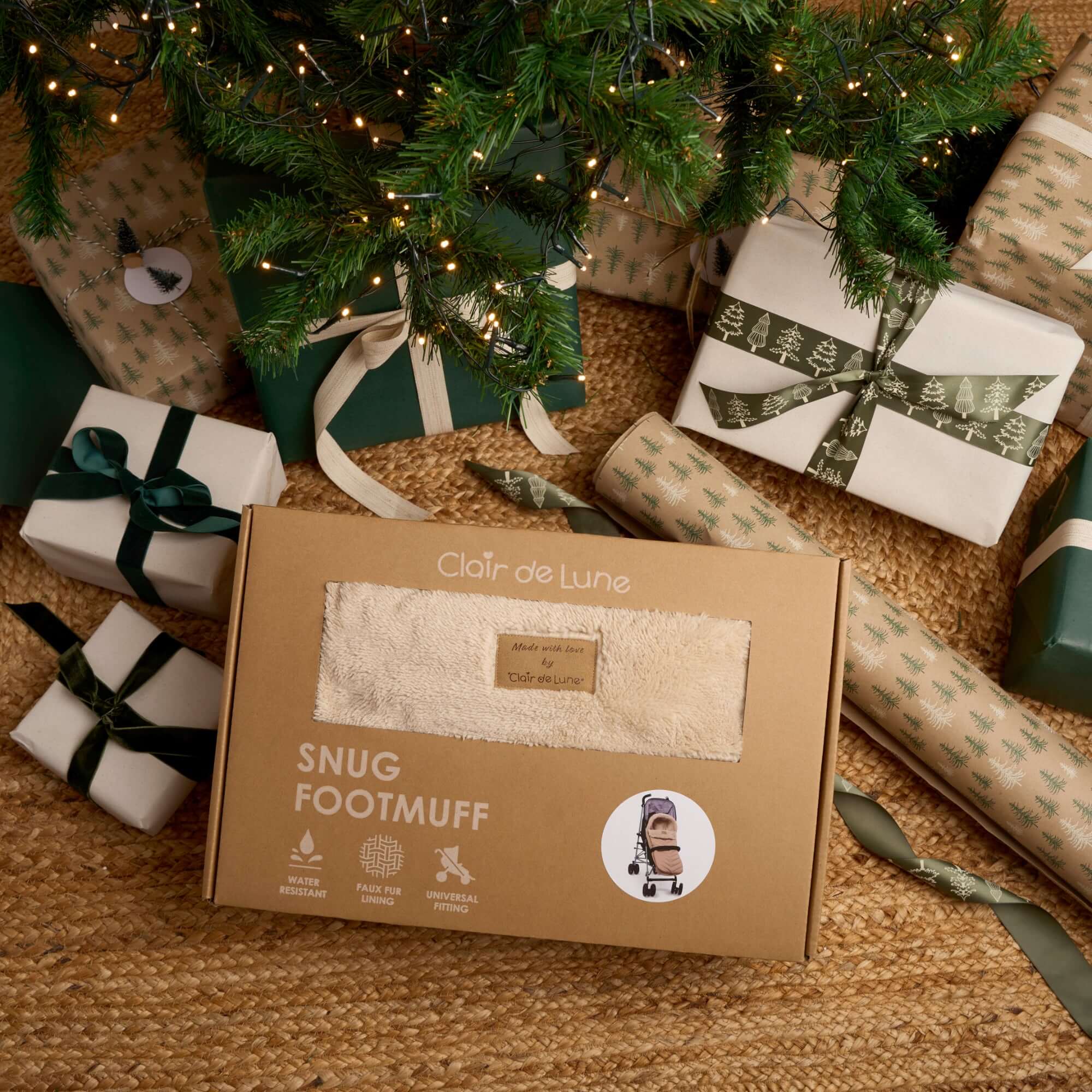 Beige Snug Universal Pushchair Footmuff in a gift box sitting under the tree on Christmas morning surrounded by presents in green and cream | Pushchair Cosytoes & Footmuffs | Travel Accessories | Baby Christmas Gifts - Clair de Lune UK