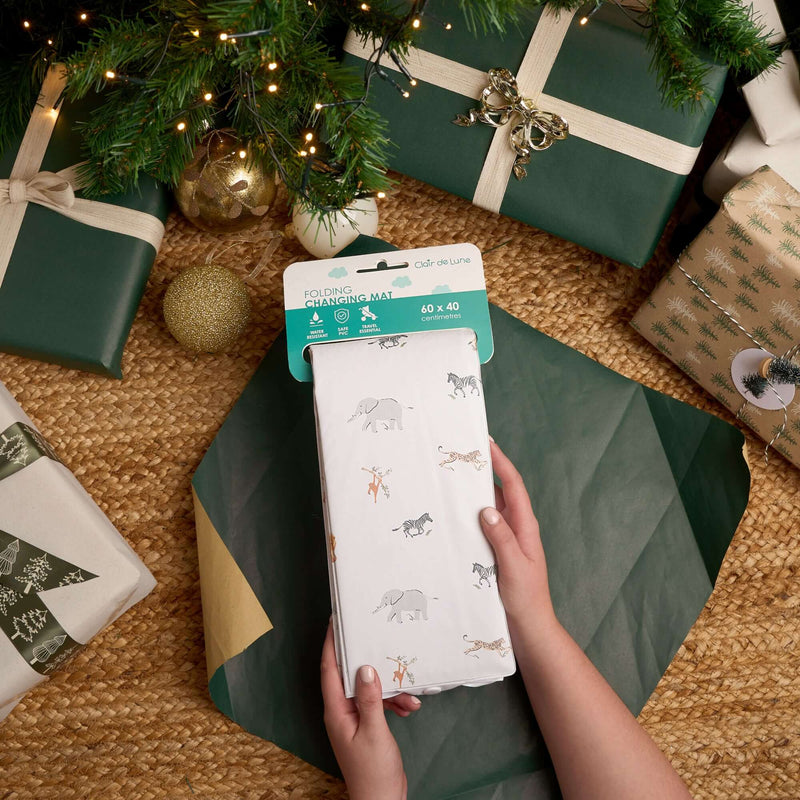 Jungle Dream Foldable Travel Changing Mat being unwrapped under the Christmas Tree surrounded by luxury wrapped green and gold xmas gifts | Baby's First Christmas | Christmas Gifts for Baby and newborn 2025 - Clair de Lune UK
