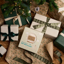 Cream star fleece baby wrap blanket being wrapped with ribbon under the Christmas tree | Cosy Star Wrap Gift Ideas | Baby's First Christmas - Clair de Lune UK