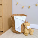 White Soft Cotton Cellular Shawl draped in a wicker basket next to a changing unit | Cosy Baby Blankets & Swaddles | Nursery Bedding | Newborn Baby Essentials - Clair de Lune UK
