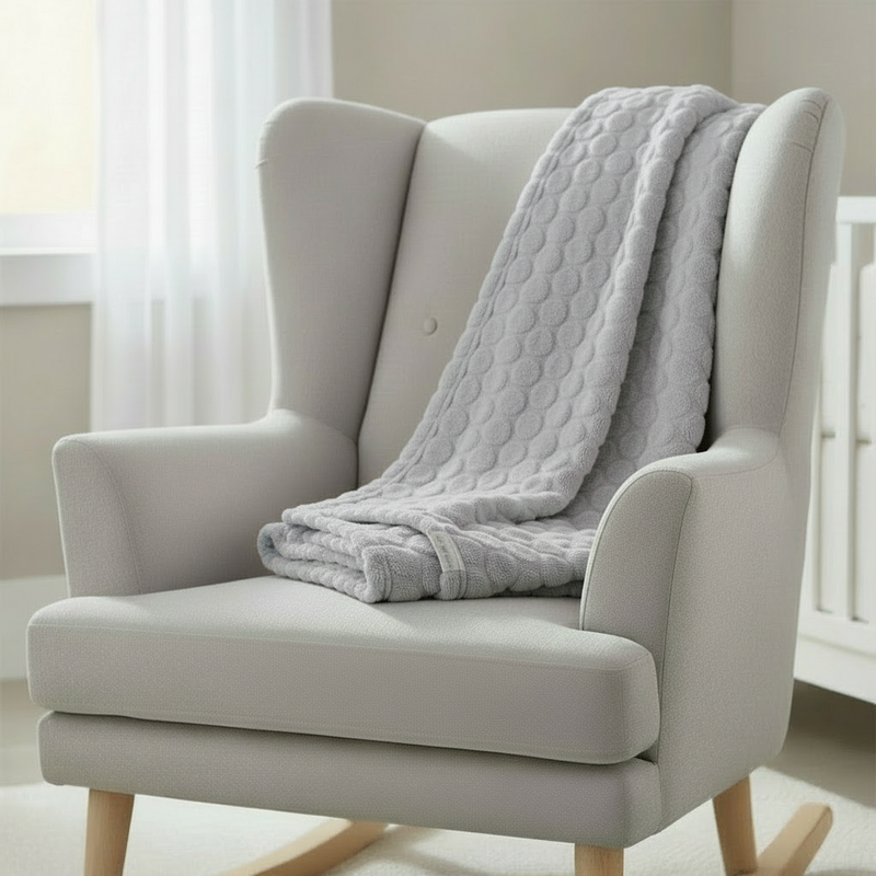 Grey Marshmallow Baby Blanket draped over a nursing chair in the nursery | Cosy Baby Blankets | Nursery Bedding - Clair de Lune UK