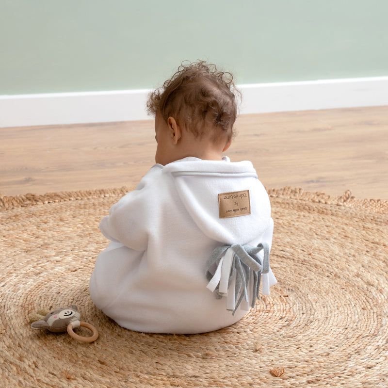 Baby playing while wearing the White Star Fleece Baby Wrap Blanket | Cosy Baby Blankets | Nursery Bedding | Newborn, Baby and Toddler Essentials - Clair de Lune UK