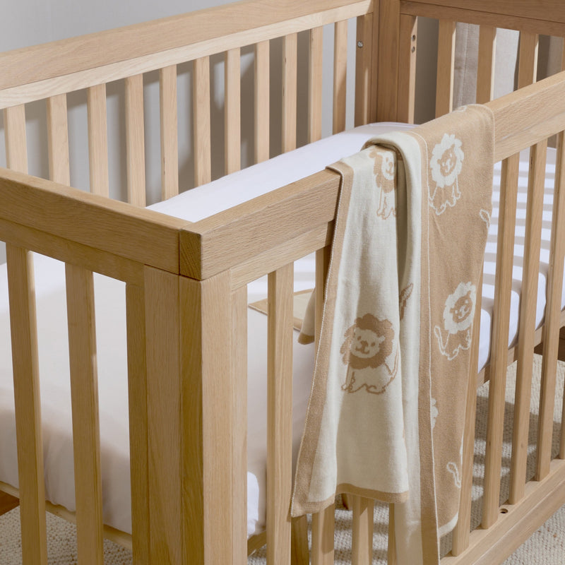 Reversible Lion Knitted Blanket on the Oak Cot Bed | Cosy Baby Blankets | Nursery Bedding | Newborn, Baby and Toddler Essentials - Clair de Lune UK
