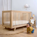 Baby crawling next to the Oak Cot Bed in a Scandi Natural Nursery Room | Cots, Cot Beds, Toddler & Kid Beds | Baby Bed | Nursery Furniture - Clair de Lune UK