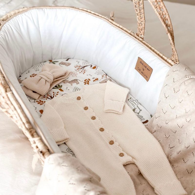 Pregnancy announcement with a baby sleeping suit in the White Savannah Palm Moses Basket | Moses Baskets | Co-sleepers | Nursery Furniture - Clair de Lune UK
