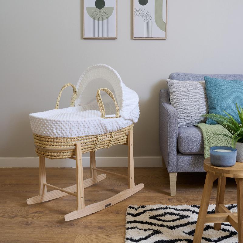 White Dimple palm Moses Basket on natural rocking stand in a greige living room next to a grey and oak sofa | Moses baby basket, bassinets | Nursery Furniture - Clair de Lune UK