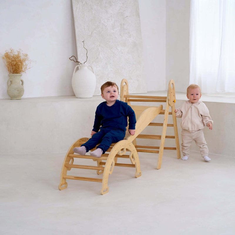 Two toddlers sliding and playing on the montessori 3 in 1 wooden activity climbing set in a minimalistic room | Toys | Indoor Play Equipment  | Climbing Frames - Clair de Lune UK
