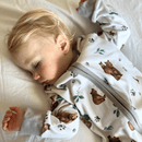 Toddler wearing the GrowGrows Organic Cozy Cubs Sleepsuit in the cot bed | Baby Grows and Onesies | Organic Baby Clothes - Clair de Lune UK