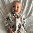 Laughing toddler wearing the GrowGrows Organic Cozy Cubs Sleepsuit in the nursery | Baby Grows and Onesies | Organic Baby Clothes - Clair de Lune UK