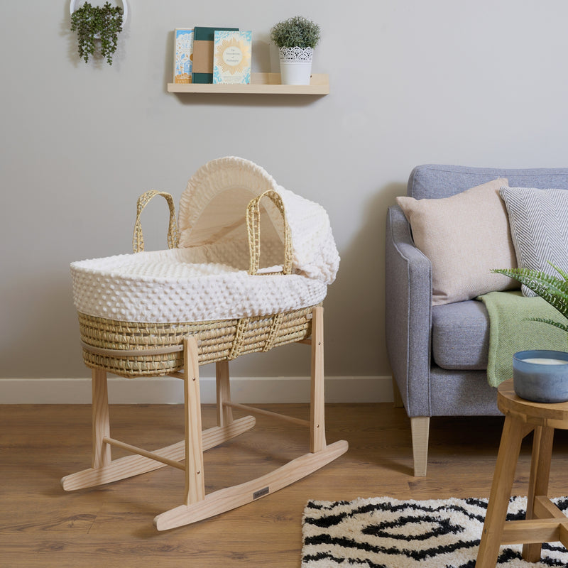 Cream Dimple Palm Moses Basket bundled with the Natural Rocking Stand in the living room next to the sofa| Moses Baby Baskets, Bassinets & Co-sleepers | Nursery Furniture - Clair de Lune UK