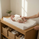 Baby lying on the Dash Anti-Roll Wedge Baby Changing Mat on a stylish Oak changing unit | Baby Bath Time Essentials - Clair de Lune UK