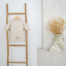 Baby onesie with unisex dash pattern with matching hat from the Little Dreamers Luxury Organic Gift Set on a wooden ladder against a white wall with a vase of dried flowers | Newborn Gift Set | Baby Grow | Organic Nursery Range - Clair de Lune UK