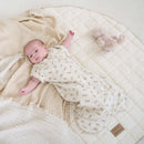 Newborn baby wearing Little Dreamers Luxury Organic Swaddle Bag lying on an organic play mat | Baby Swaddle Bag | Newborn Sleeping Bag | Nursery Bedding - Clair de Lune