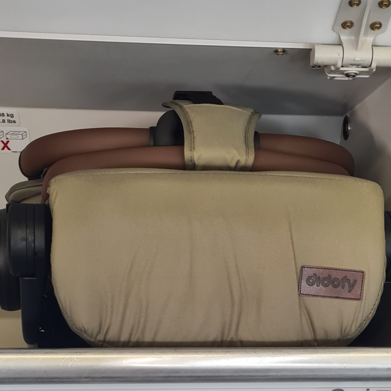 Folded Didofy Green New Aster 2 Ultra-Compact Pushchair & Travel System on the overhead bin of an airplane as a carryon | Didofy | Pushchairs and Travel Systems | Baby & Kid Travel - Clair de Lune UK