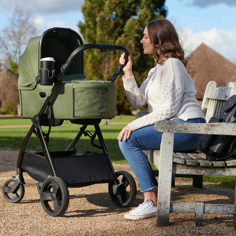 Mom next to her Didofy Stargazer Green Collapsible Carrycot in a park | Moses Baskets | Co-sleepers | Travel Cribs | Baby & Kid Travel - Clair de Lune UK