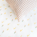 Close up of the fabric pattern of Gingham and Ducklings with Reeds Reversible Little Duckling Cot Bed Duvet Cover and Pillowcase Set on a duvet | Toddler and Baby Bedding | Nursery Linen - Clair de Lune UK