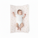 Baby lying on the Duckling Anti-Roll Wedge Baby Changing Mat on a white background | Baby Bath Time Essentials - Clair de Lune UK