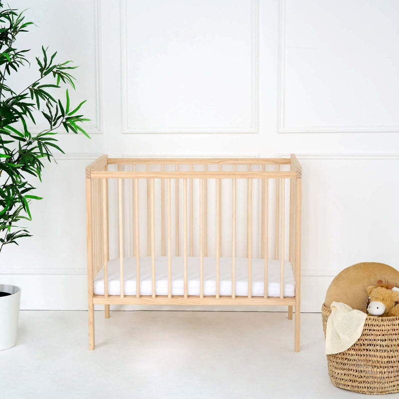 Natural East Coast Space Saver Cot  with mini mattress in a white nursery with play basket | Cots, Cot Beds & Toddler Beds | Nursery Furniture - Clair de Lune UK
