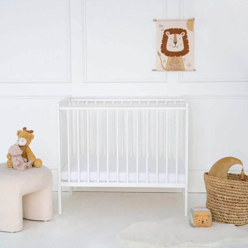 White East Coast Space Saver Cot  with mini mattress in a white nursery with play basket | Cots, Cot Beds & Toddler Beds | Nursery Furniture - Clair de Lune UK