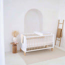 White Essentials Cot Bed with the Essentials Cot Top Changer in a bright white minimalist nursery room | Cots, Cot Beds & Toddler Beds | Nursery Furniture - Clair de Lune UK