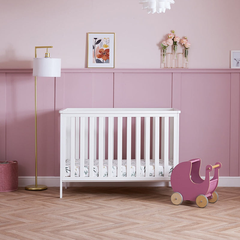 White Obaby Evie Mini Cot Bed in a pastel pink Disney princess-theme nursery room | Cots, Cot Beds, Toddler & Kid Beds | Nursery Furniture - Clair de Lune UK
