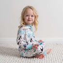 Toddler sat on the floor wearing the Grow Grows Organic Arctic Animals Sleepsuit in a white room | Baby Grows and Onesies | Organic Baby Clothing - Clair de Lune UK