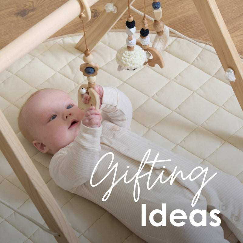 Baby Playing with the Wooden Play Gym lying on the Organic Play Mat | Gifts & Toys | Baby Gift Ideas - Clair de Lune UK