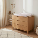 Brown Gingham Anti-Roll Wedge Baby Changing Mat on an oak changing unit by a bright window | Baby Bathing & Changing Essentials - Clair de Lune UK