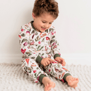 Boy sat down looking at the vegetable print on the Grow Grows Organic Allotment Adventure Pyjamas that he is wearing | Organic Kids PJs and Nightwear - Clair de Lune UK