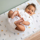 Smiling baby lying on the Jungle Dream Anti-Roll Wedge Baby Changing Mat holding their toes |  Change & Travel Mats | Baby Bath Time Essentials - Clair de Lune UK