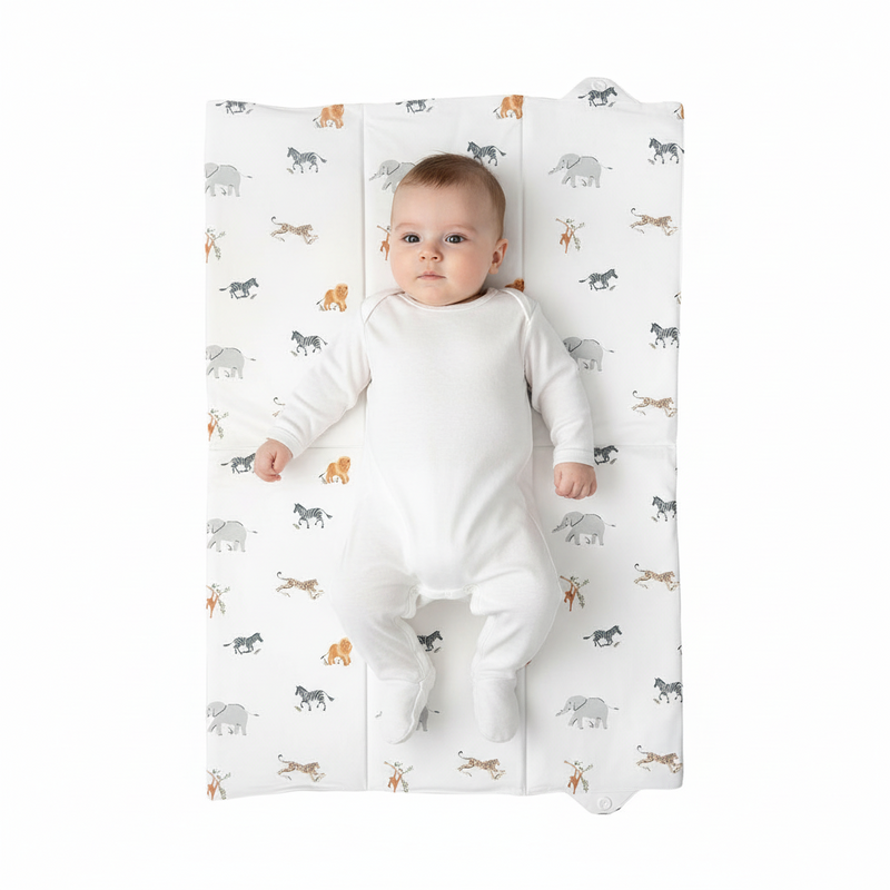 Baby lying on the Jungle Dream Foldable Travel Changing Mat laid out flat | Baby Change Mat | Bathing & Changing Essentials - Clair de Lune UK