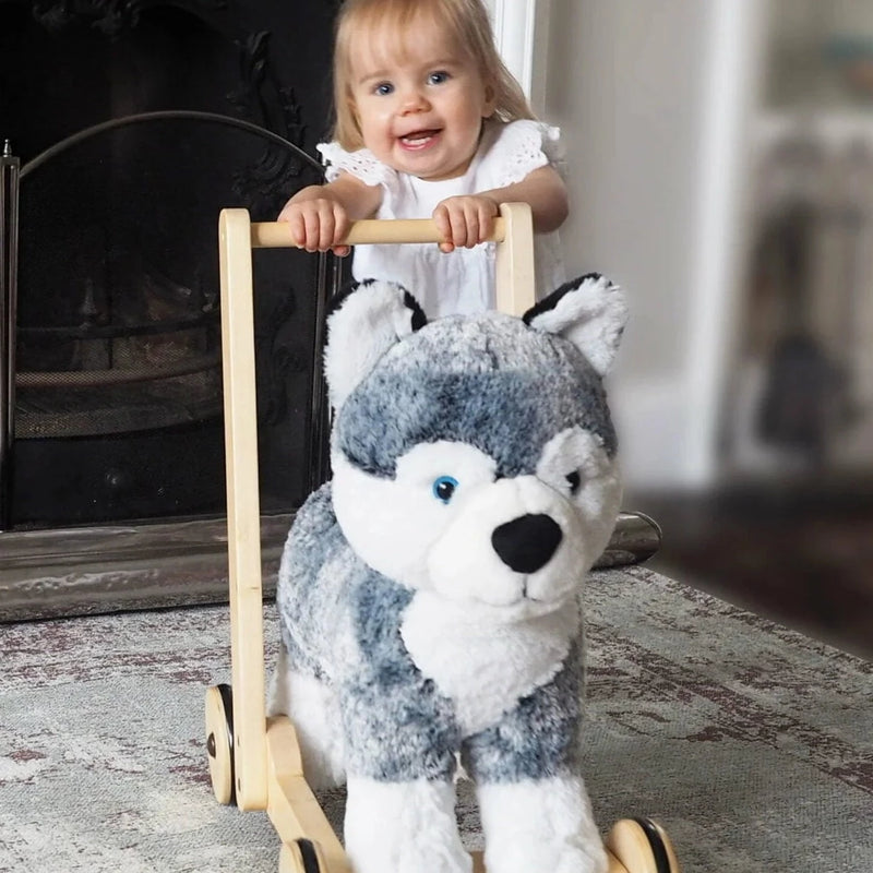 Toddler girl pushing her favourite Little Bird Told Me Mishka Dog 2in1 Push Along, Baby Walker and Ride On | Baby Walkers and Ride On Toys | Montessori Activities For Babies & Kids | Toys | Baby Shower, Birthday & Christmas Gifts - Clair de Lune UK