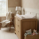 Little Duckling Anti-Roll Wedge Baby Changing Mat in a stylish nursery with Oak changing unit, wood panelling and scandi chair and toy basket | Baby Bathing & Changing Essentials - Clair de Lune UK