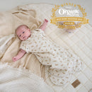 Newborn baby wearing Little Dreamers Luxury Organic Swaddle Bag lying on an organic play mat, a 2026 Gold Award Winner for the best baby sleeping bag | Baby Swaddle Bag | Newborn Sleeping Bag - Clair de Lune UK