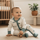 Baby sat on the floor of the nursery wearing the Grow Grows Organic Little Summit Sleepsuit | Baby Grows and Onesies | Organic Baby Clothes - Clair de Lune UK