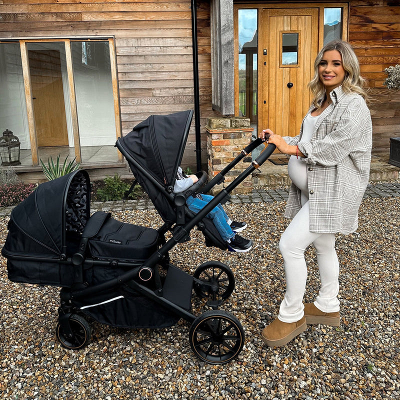 Dani Dyer next to her babies in My Babiie MB33 Dani Dyer Black Leopard Tandem Pushchair | Buggies, Strollers & Pushchairs | Travel With Your Baby - Clair de Lune UK