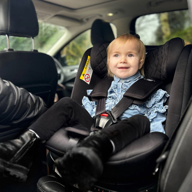 Happy baby sitting on the My Babiie Billie Faiers iSize Quilted Black Spin Car Seat (40-150cm) | Baby, Toddler & Kid Car Seats | Travel With Baby - Clair de Lune UK