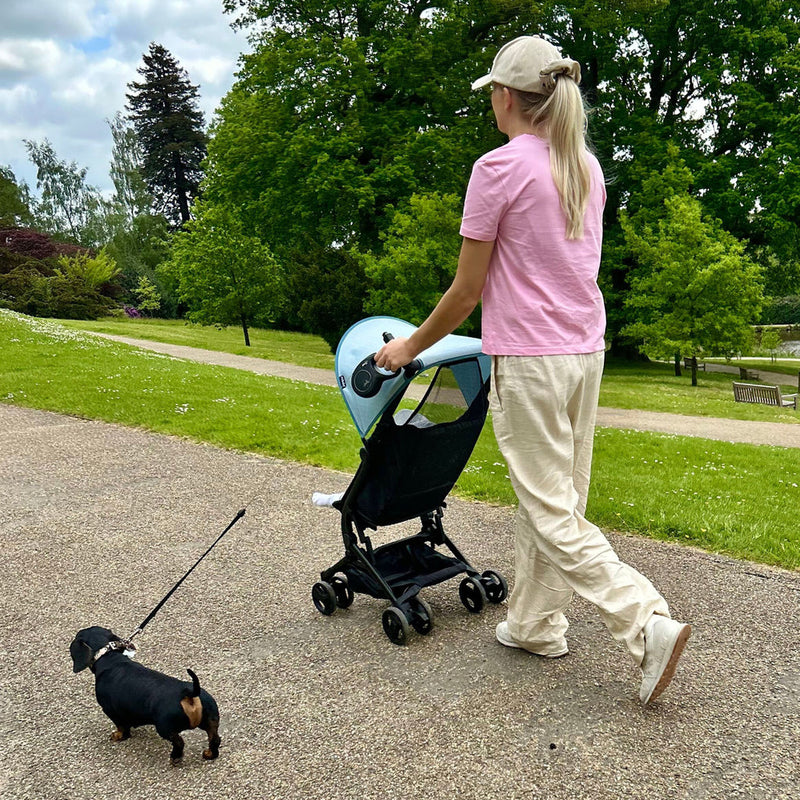 Mom pushing the My Babiie MBX5 Ultra Compact & Aeroplane Carry-on Approved Samantha Faiers Blue Stroller while walking her dog | Buggies, Strollers & Pushchairs | Travel With Your Baby - Clair de Lune UK