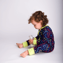 Boy sat drinking milk wearing the GrowGrows Organic Neon Nightlife Sleepsuit | Baby Grows and Onesies | Organic Baby Clothes - Clair de Lune UK