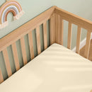 Organic Cream Fitted Cotton Cot Bed Sheet - 140 x 70 cm on a solid oak cot bed mattress | Soft Baby Sheets | Cot & Cot Bed Bedding | Nursery Linen - Clair de Lune UK