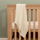 Cream Organic Cotton Cellular Blanket draped on the Solid Oak Cot Bed | Cosy Baby Blankets & Swaddles | Nursery Bedding | Newborn Baby Essentials - Clair de Lune UK